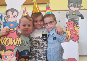 Chłopcy pozują do zdjęcia w fotobudce.