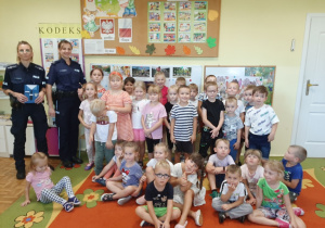 Dzieci z paniami policjantkami pozują do fotografii.