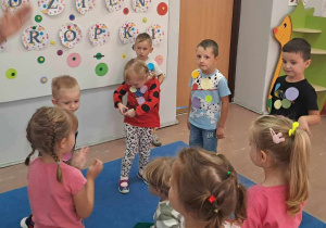 Dzieci w czasie zabawy na dywanie z papierowymi kropkami