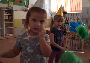 Dziewczynki z czapeczkami na głowach i pomponami w czasie zabawy