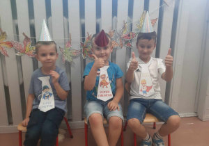 Chłopcy z grupy starszej ubrani w czapeczki i krawaty