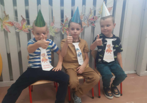 Chłopcy z grupy starszej ubrani w czapeczki i krawaty