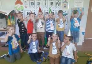 Grupowe zdjęcie chłopców starszaków. W tle napis Dzień Chłopaka