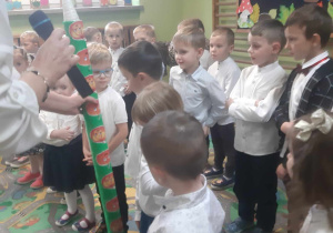 Dzieci oglądają kredkę do pasowania trzymaną przez p. dyrektor