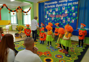 Pani dyrektor prezentuje "dyniowy ołówek" do pasowania na przedszkolaka.