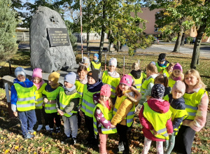 Grupa przedszkolaków pozująca do fotografii przy obelisku w Wartkowicach upamiętniającym poległych w walce o ojczyznę