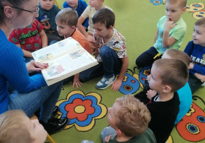 Mama dziecka czyta przedszkolakom książkę