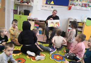 Mama dziecka czyta przedszkolakom książkę