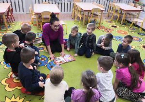Mama dziecka czyta przedszkolakom książkę