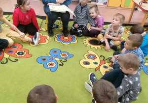 Mama dziecka czyta przedszkolakom książkę