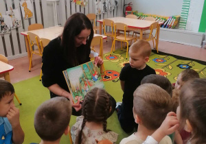 Mama dziecka czyta przedszkolakom książkę