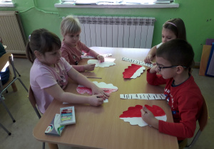 Przedszkolaki przygotowują elementy patriotycznej dekoracji.