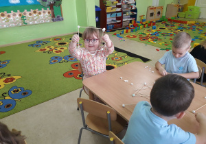 Dzieci podczas zabaw konstrukcyjnych przy stolikach.