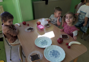 Dzieci przy stolikach wykonują "misiowe kanapki".