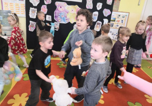 Chłopcy tańczą w kółeczku z misiami.