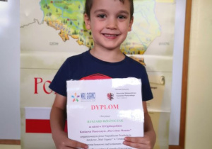 Chłopiec prezentuje dyplom za udział w konkursie.