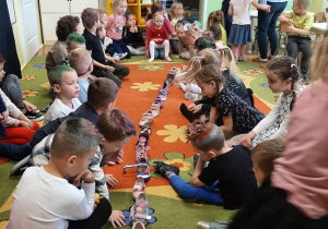 Dzieci na dywanie podczas wróżby z butami.