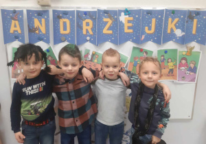 Chłopcy z grupy 5-6 latków w dziwnych fryzurach na tle dekoracji andrzejkowej