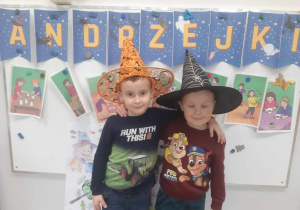 Chłopaki w kapeluszach na tle dekoracji andrzejkowej