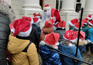 Dzieci stoją zwrócone w stronę Mikołaja