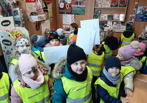 Dzieci pozują na poczcie do fotografii. Trzymają koperty z listami do Mikołaja.