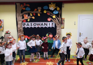 Przedszkolaki w wiankach na głowach śpiewają piosenkę.