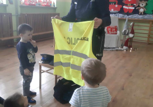 Policjantka pokazuje kamizelkę odblaskową
