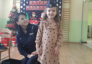 Policjantka z dziewczynką z przymierzoną czapką policyjną