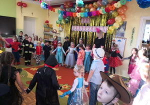 Przedszkolaki stoją w dużym kole i śpiewają piosenkę.