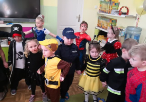 Dzieci trzymają się za ręce podczas zabawy muzycznej.