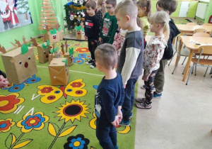 Dzieci podczas zajęcia przeliczają renifery w zagrodach.