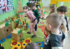 Zabawy matematyczne dzieci z wykorzystaniem sylwet reniferów.