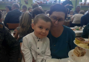 Babcia z wnukiem siedzą przy stole