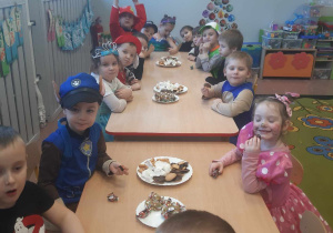 Dzieci w czasie poczęstunku w sali przedszkolnej.