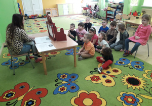 Mama Oliwia prezentuje dzieciom teatrzyk kamishibai.