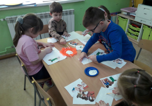 Dzieci przy stolikach układają puzzle pt. "Krasnoludki".