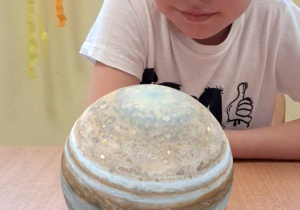 Chłopiec prezentuje planetę z wykorzystaniem karty 3D.