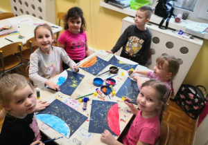 Grupa starszaków wykonuje pracę plastyczną.