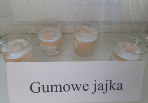 Doświadczenie "Gumowe jajka". W szklankach umieszczono jajka, zalani je octem.
