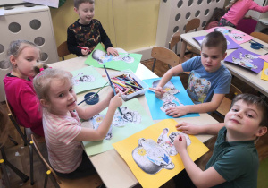 W marcu jak w garncu. Kolejna grupa dzieci siedzi przy stoliku, wykonuje pracę plastyczną.