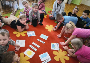 Dzieci podczas zabawy w języku angielskim. Siedzą w kręgu. Nazywają zjawiska pogodowe po angielsku.
