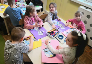 W marcu jak w garncu. Dzieci siedzą przy stoliku, wykonują pracę plastyczną.