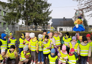 Dzieci z grupy 5,6 latków pozują na placu przedszkolnym trzymając Marzannę.