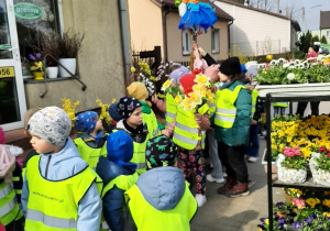 Dzieci wraz z Marzanną przechodzą obok pobliskiej kwiaciarni.