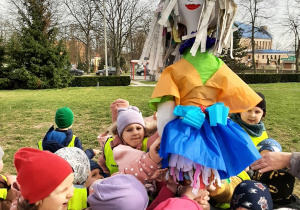 Przedszkolaki skupione przy kukle Marzanny, żegnają zimę recytując rymowankę.