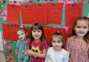 Dziewczynki z grupy starszej na tle dekoracji na Dzień Kobiet
