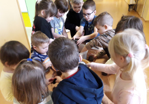 Dzieci napełniają doniczki ziemią.