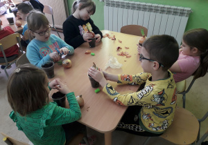 Dzieci sadza cebulkę do doniczek.