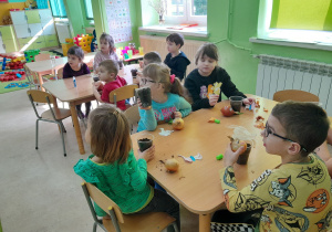 Dzieci sadza cebulkę do doniczek.