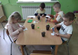 Dzieci sadza cebulkę do doniczek.